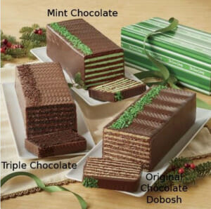 Chocolate, mint and triple chocolate dobosh tortes on plates, each with one slice showing the layers.