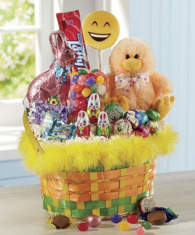 Fuzzy chick Easter basket filled with an assortment of foiled chocolate candies and jelly beans.