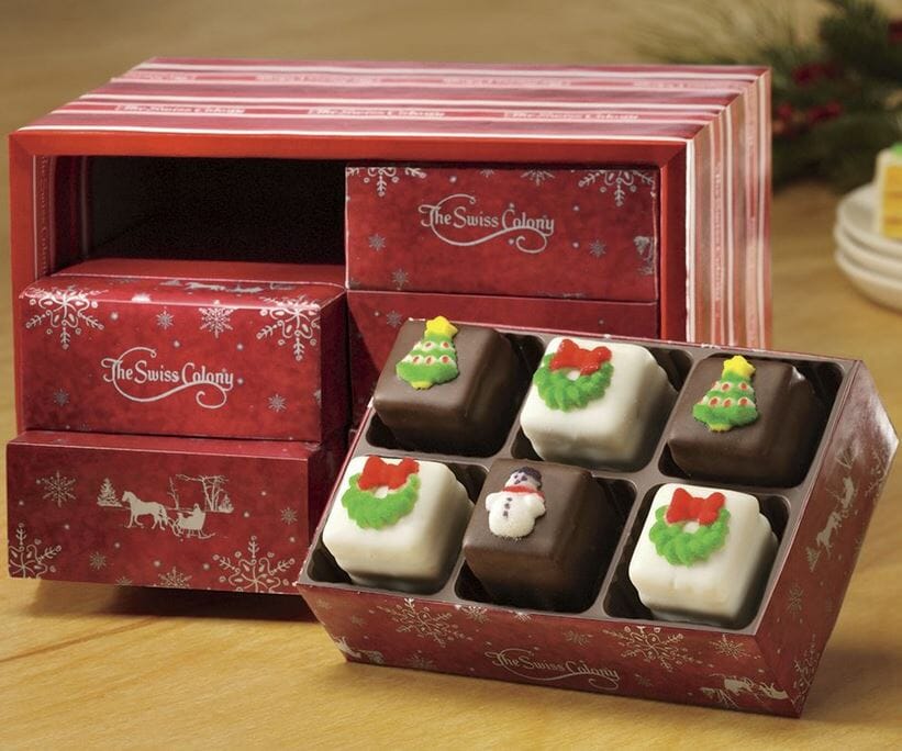 Petits Fours Stocking Stuffers in six small red snowflake boxes, filled with decorated Christmas Petits Fours.