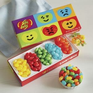Assortment of yellow, red, green, blue and orange emoji jelly beans in a jelly belly box.