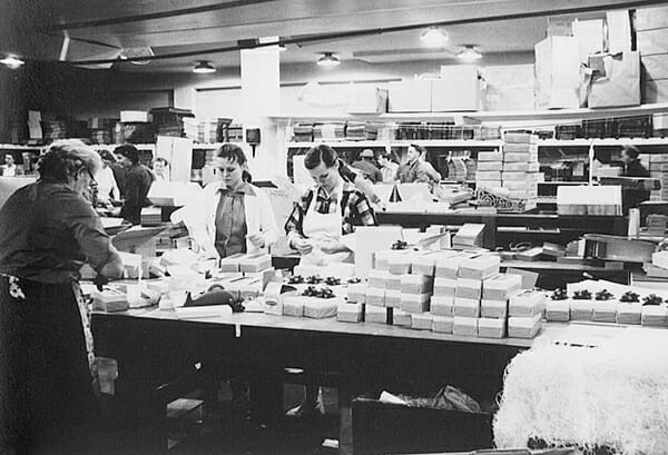 Bakery workers packaging dobosh tortes in a pre-1970's setting.