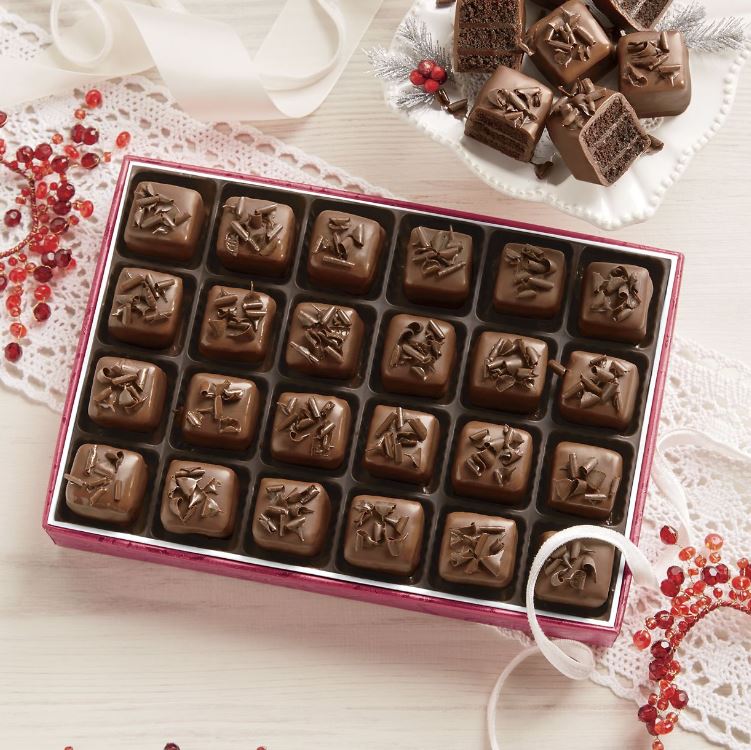 Royal Chocolate Petits Fours in a red Swiss Colony box with a side plate of sliced, layered Petits Fours.