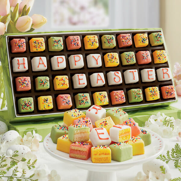 A box of 36 petits fours in spring colors with some spelling out “Happy Easter” in icing