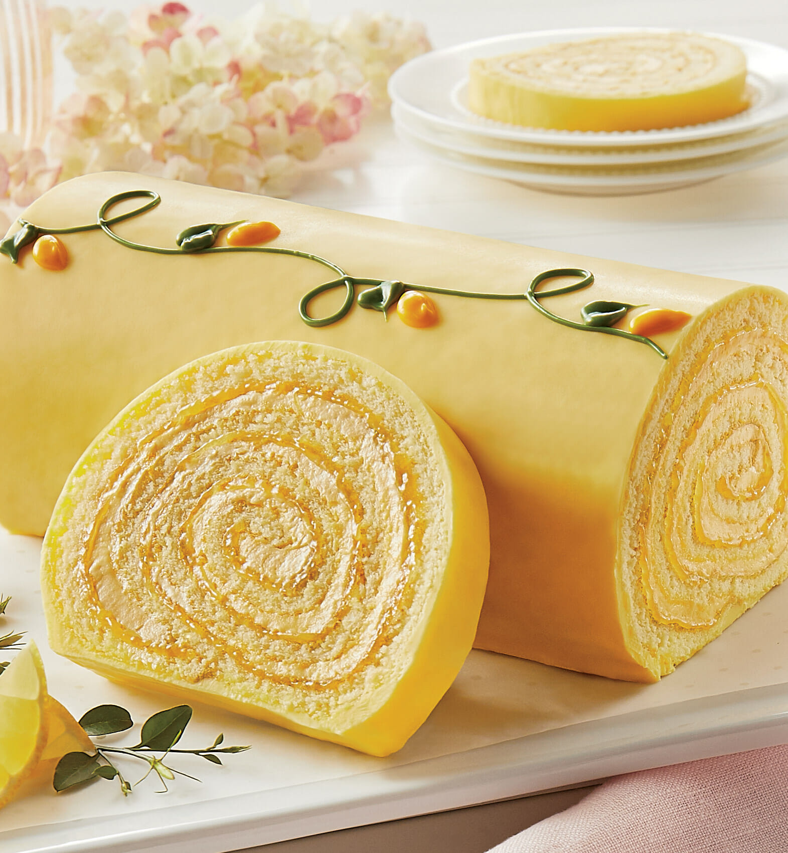 A yellow Swiss Roll-type cake coated in confection and hand decorated with icing