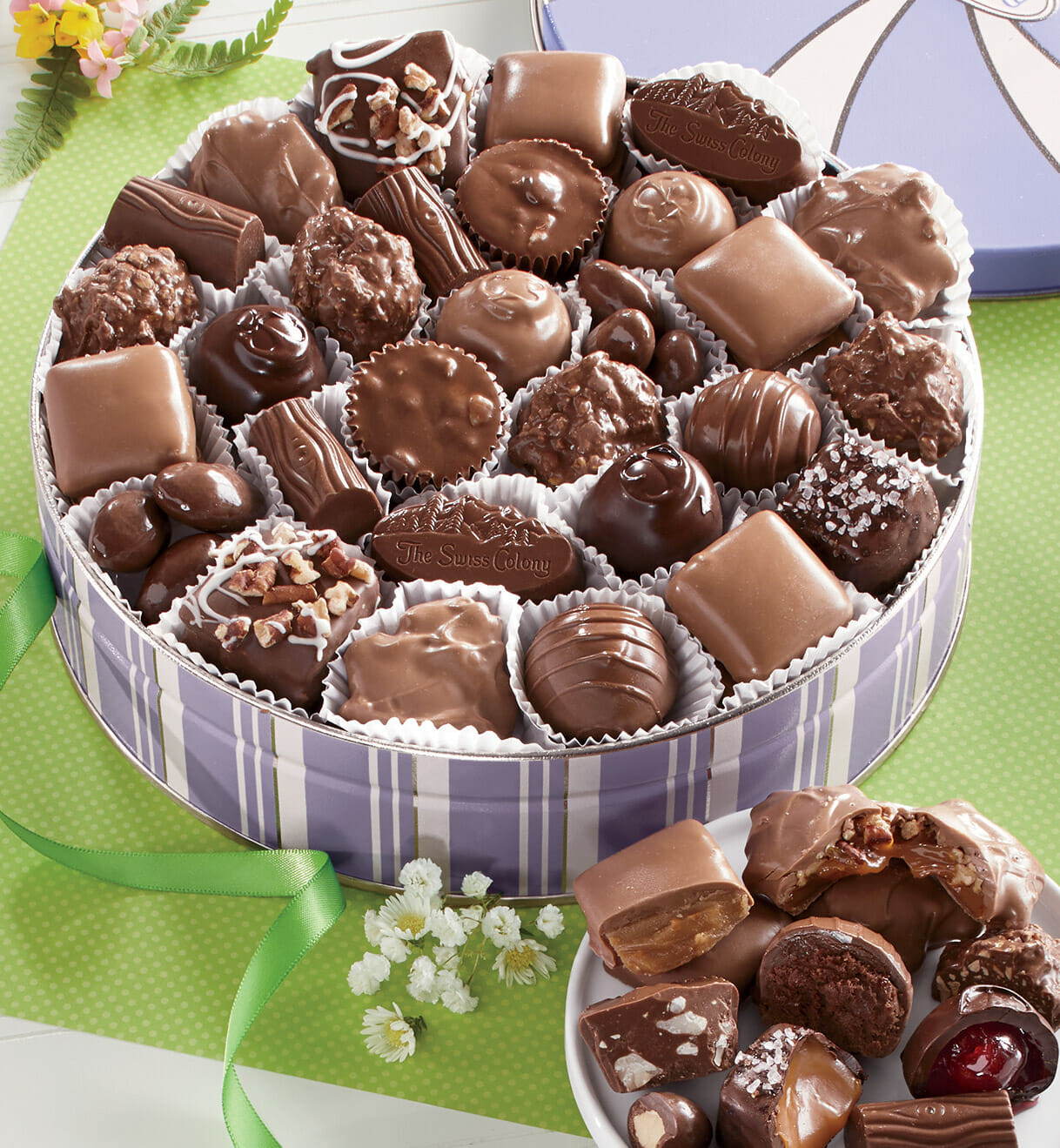A lavender-and-white striped gift tin filled with a variety of chocolates